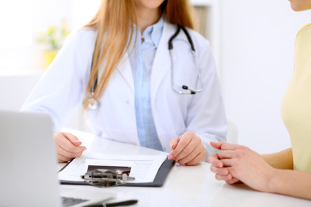 Doctor and patient are discussing something, just hands at the tableの写真素材