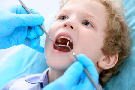 Close up of boy having his teeth examined by a dentistの写真素材