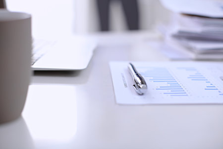 Office workplace with a laptop and financial documentsの写真素材