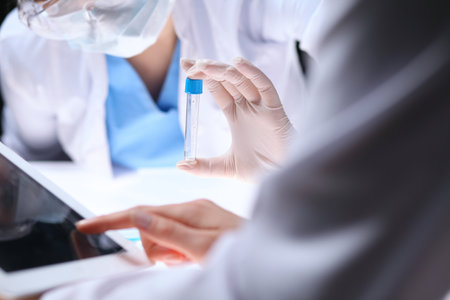 Close up of scientific research team with clear solution in laboratoryの写真素材