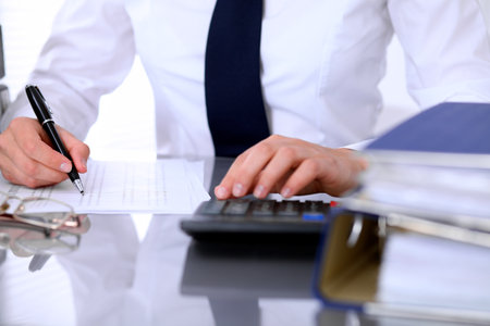 Close up of business woman making report, calculating or checking balance.の写真素材