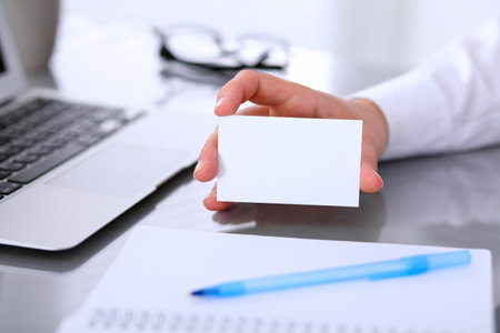 Close-up of business woman giving a visit cardの写真素材