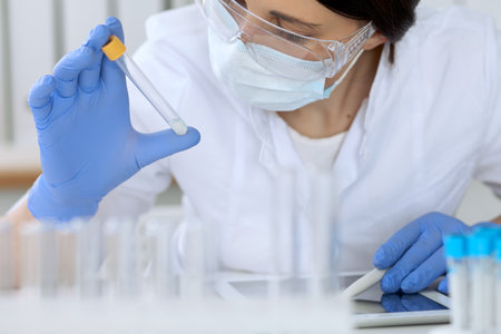 Close up of scientific research hands with clear solution in laboratoryの写真素材