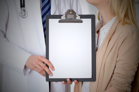 Doctor and patient holding clipboard free copy space. Medical ethics and trust conceptの写真素材