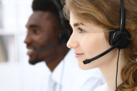 Call center operator.Young beautiful business woman in headset.の写真素材