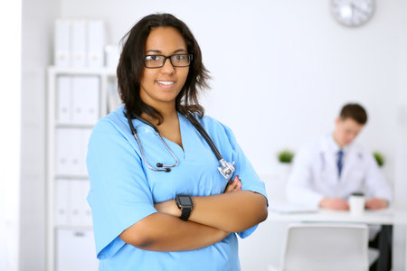 Female african american medical doctor with colleagues in background.の写真素材