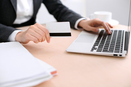 Close up of business woman hands using credit card and laptop computerの写真素材
