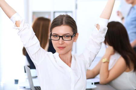Portrait of a young business woman against a group of business people at  meeting.の写真素材