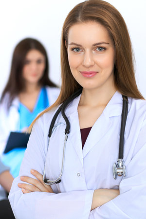 Young beautiful female doctor smiling to patient while consulting her.の写真素材