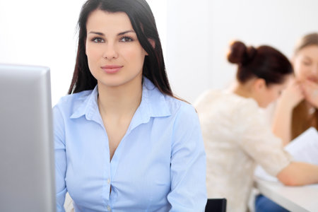 Young businesswoman sitting at desk and workingの写真素材