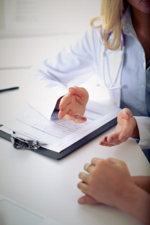 Doctor and patient are discussing something, just hands at the table.の写真素材