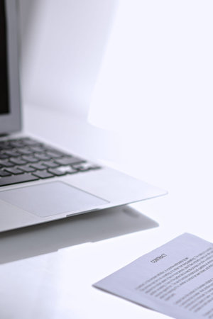 Office workplace with a laptop and contract document