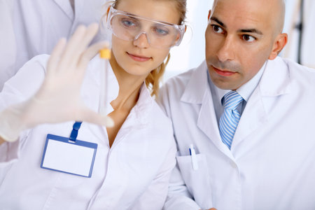 Scientific research team with clear solution in laboratoryの写真素材