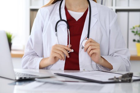 Unknown female doctor with a stethoscope in the hands. Physician is redy to exemine a patient. Medicine and health care coneptの写真素材