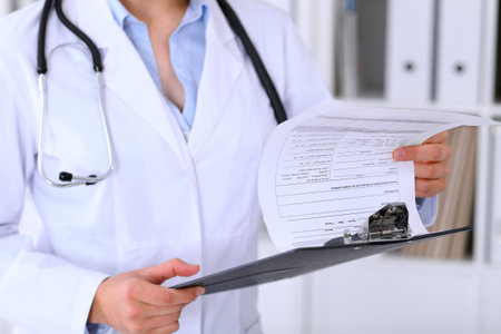 Close-up of a female doctor is filling  out application form or medical historyの写真素材