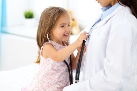 Happy little girl at  health exam at doctors officeの写真素材