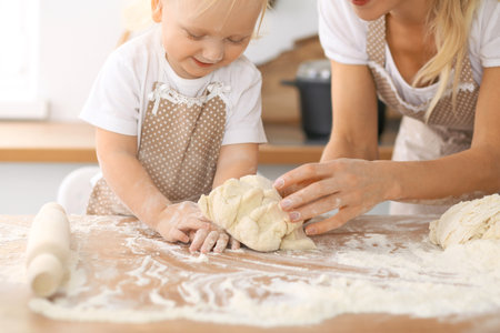 Happy family in the kitchen. Mother and child daughter cooking holiday pie or cookies for Mothers dayの写真素材