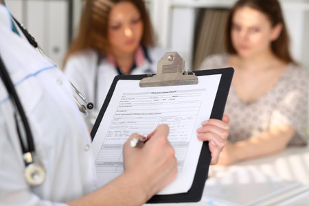Close-up of a female doctor while filling up medical history recordの写真素材