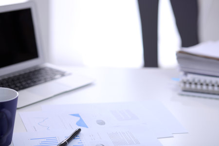 Office workplace with a laptop and financial documentsの写真素材