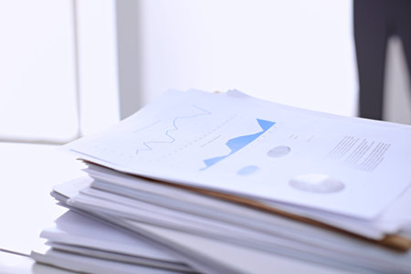 Office workplace with a laptop and financial documentsの写真素材