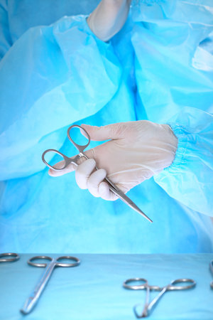 Close-up of of surgeons hands at work in operating theater toned in blueの写真素材