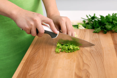 Close up of woman's hands cooking in the kitchen. Housewife slicing fresh salad. Vegetarian and...