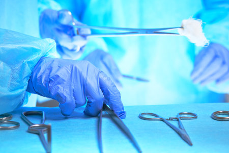 Close-up of of surgeons hands at work in operating theater toned in blue. Medical team performing operationの写真素材