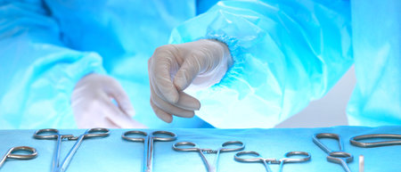 Close-up of of surgeons hands at work in operating theater toned in blue