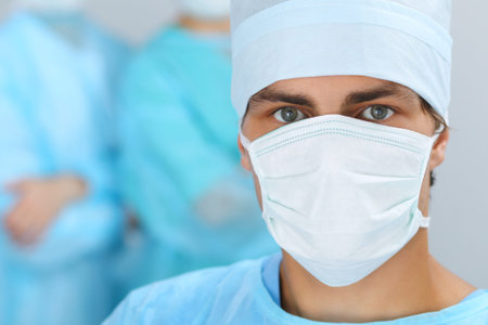 Medical team performing operation. Focus at male doctor