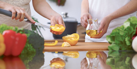 Close-up of four human hands are cooking in a kitchen. Friends having fun while preparing fresh salad. Chef cook represent culinary masterclass. Vegetarian, healthy meal and friendship conceptの写真素材