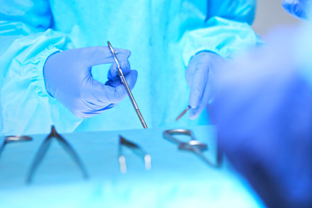 Close-up of of surgeons hands at work in operating theater toned in blue. Medical team performing operationの写真素材