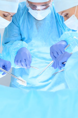 Group of surgeons at work while operating at hospital. Health care and veterinary concept.の写真素材