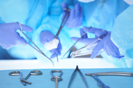 Close-up of medical team performing operation. Group of surgeons at work are busy of patient....