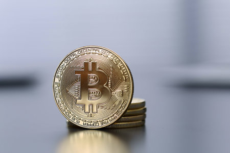 Golden Bitcoin facing the camera in sharp focus, closeupの写真素材