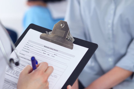 Close Up of a female doctor filling  out application form while talking to patient. Medicine and health care conceptの写真素材