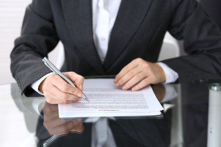 Close-up of female hands with pen over document,  business conceptの写真素材
