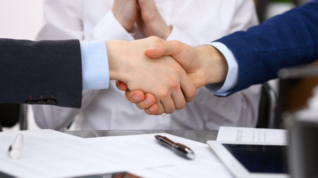 Business people shaking hands, finishing up a meeting. Audit, tax service or agreement conceptの写真素材
