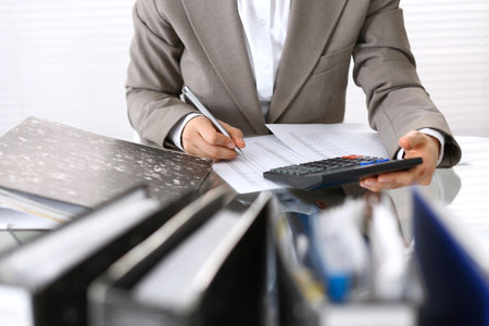 Female bookkeeper or financial inspector  making report, calculating or checking balance. Internal Revenue Service checking financial document. Audit concept in businessの写真素材