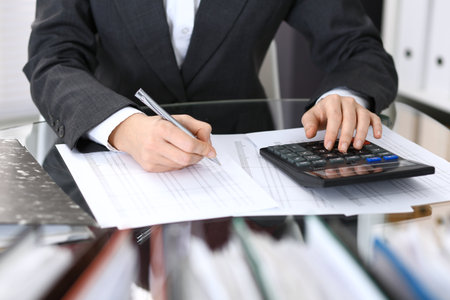 Female bookkeeper or financial inspector  making report, calculating or checking balance. Internal Revenue Service checking financial document. Audit concept in businessの写真素材