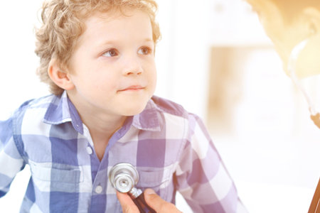 Doctor and child patient. Physician examines little boy by stethoscope. Medicine and childrens therapy conceptの写真素材