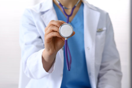 Doctor holds stethoscope head, closeup. Physician ready to examine and help patient. Medical help and insurance in health care, best treatment and medicine conceptの写真素材