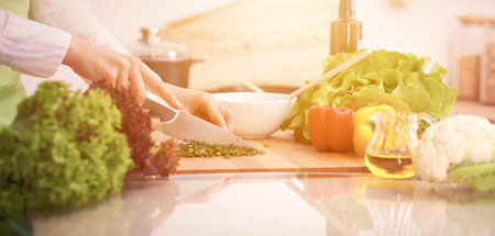Close Up of human hands cooking vegetable salad in kitchen on the glass table with reflection....