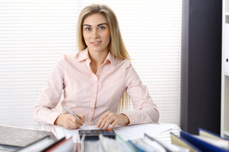 Portrait of female bookkeeper or financial inspector  making report, calculating or checking balance. Copy space areaの写真素材