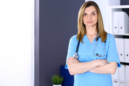Woman doctor at work in hospital office. Portrait of female physician with arms crossed. Medicine and health care conceptの写真素材