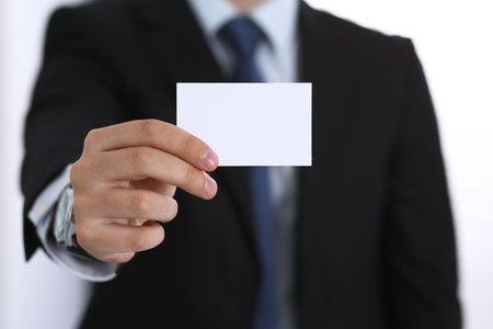 Businessmans hand holding business card with empty spaceの写真素材
