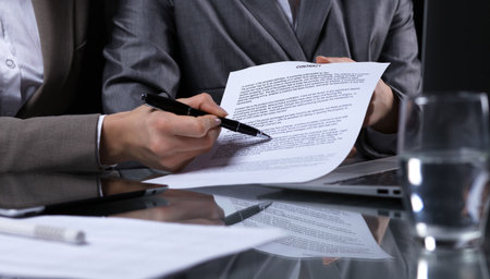 Businesspeople or lawyers signing contract at meeting. Close-up of human hands at work. Low key lightingの写真素材