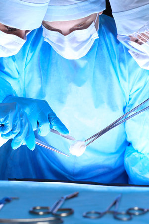 Group of surgeons in masks performing operation. Medicine, surgery and emergency help conceptsの写真素材