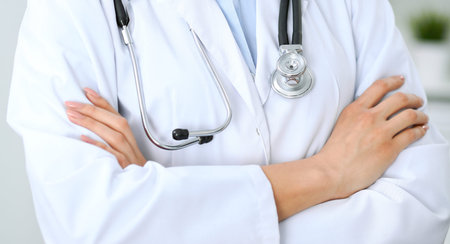 Closeup of doctor woman standing with arms crossed at hospital.  Health care, insurance and help concept.の写真素材