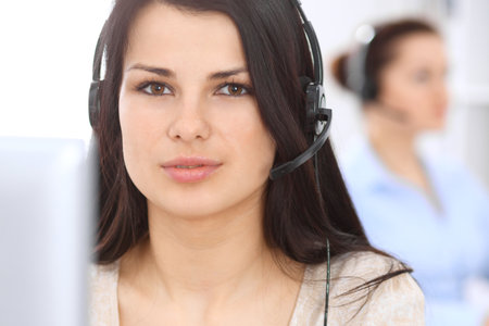 Young businesswoman sitting at desk and while consulting clients. Customer service and business conceptの写真素材