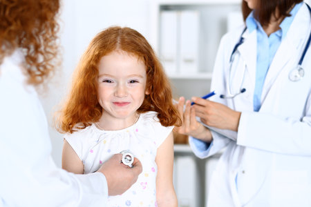 Doctor examining a little girl with stethoscope.Medicine and healthcare conceptの写真素材